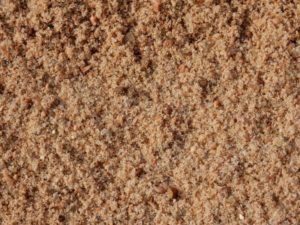 Torpedo Sand. Often mixed with cement. Can be used for help with drainage, too.